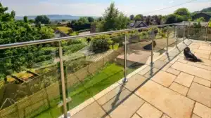 clean concrete slab patio with Glass balustrade railing overlooking small village housing estate
