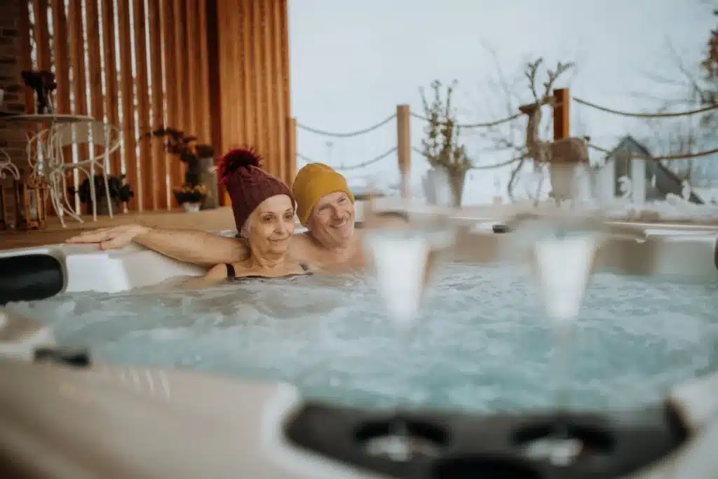 Couple relaxing in a hot tub surrounded by garden decorations on a foggy day