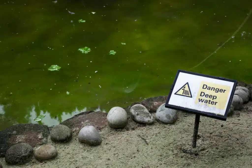 close up of a deep water safety sign in front of water