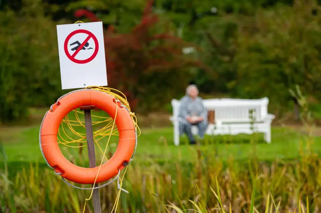 no swimming sign and float device in front of a pond
